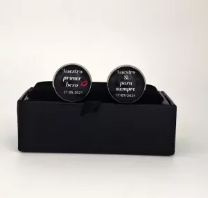 Gemelos personalizados con las frases "Nuestro primer beso" y "Nuestro Sí para siempre", acompañadas de fechas.