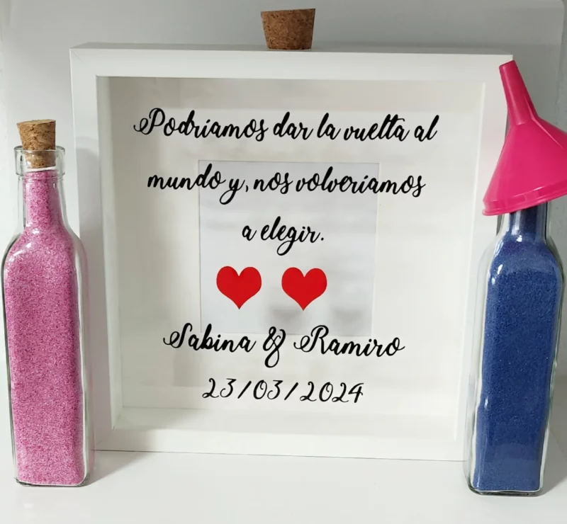 Cuadro ceremonia de la arena con la frase 'Podríamos dar la vuelta al mundo y nos volveríamos a elegir.' Un detalle romántico para bodas, simbolizando un amor sin fronteras.