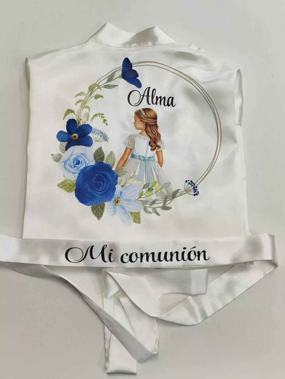 Detalle bata de comunión con nombre y flores azules